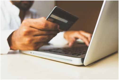 Man putting credit cart details in laptop